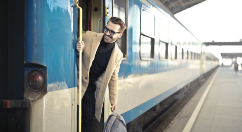 Bild på man med väska som kliver av ett tåg.