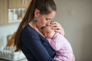 Mor håller dotter i famn