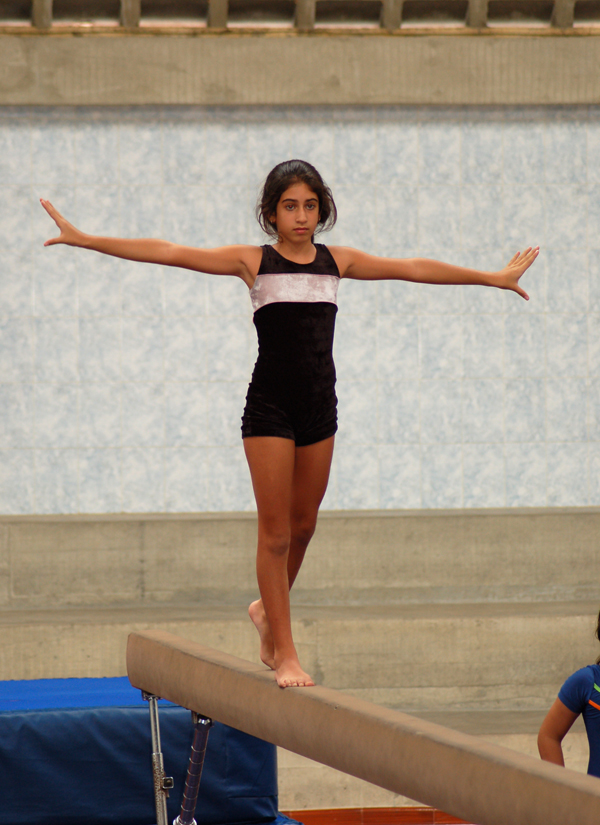 Flicka gör gymnastikövning under idrottslektion. Foto: Bongoman/Wikimedia Commons