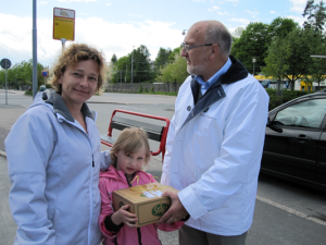 Annika Hadzic och dottern Hanna tar emot en av tårtorna i Kristdemokraternas lotteri från Christer Fjordevik (KD). (Foto: Arnold Carlzon)