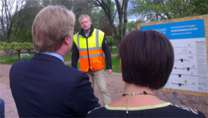 Mannen med frisyren, Lars Adaktusson (KD), lyssnar intresserat när Ronnie Björkström berättar om de pågående arbetena med att bygga fördämningar och pumpstationer i Värnamos finpark, Åbroparken. (Foto: Håkan Johansson)